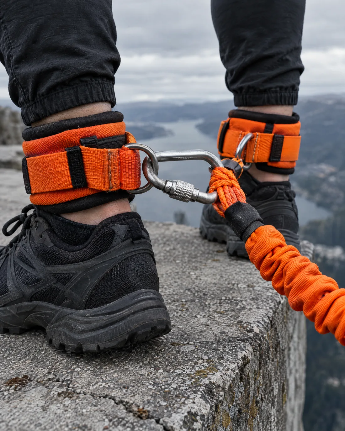Orange gepolsterte Knöchelgurte mit Stahlkarabiner am Ende des Bungee-Seils